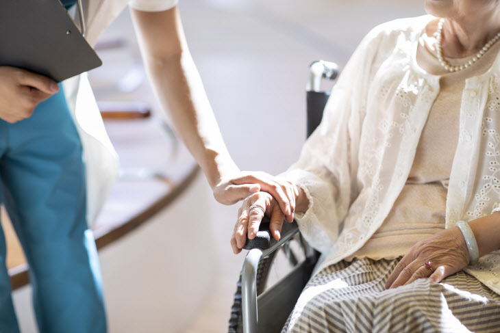 Young doctor with patient in nursing home